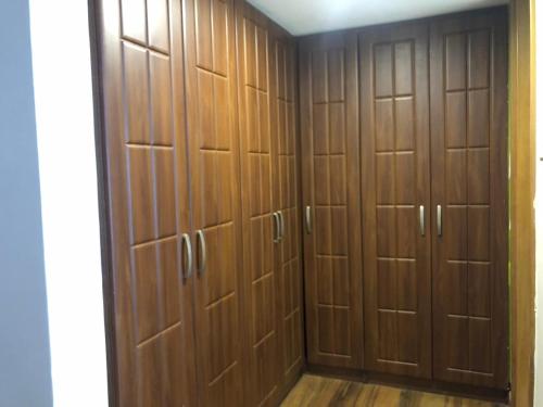 a closet with wooden lockers in a room at Enkombe Place in Kampala
