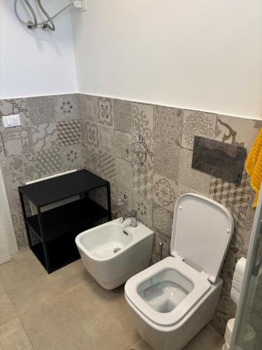 a bathroom with a toilet and a sink at Flamingo Apartment in Pachino