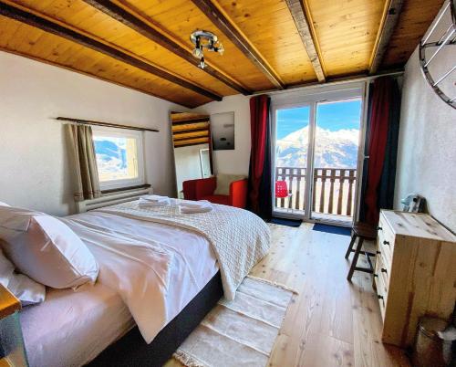 a bedroom with a bed and a large window at Chalet Les Crettaux Skigebiet NENDAZ by fewo-plan in Iserables