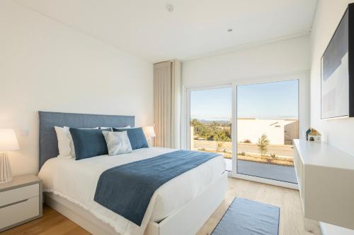 a bedroom with a bed and a large window at Pestana Valley in Estômbar