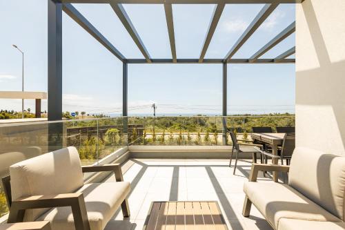 a balcony with chairs and a table with a view at Pestana Valley in Estômbar