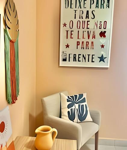 a living room with a chair and a picture on the wall at Studio AKN 2 (FIASP, USP, CPO, Mondelli, FACOP) in Bauru