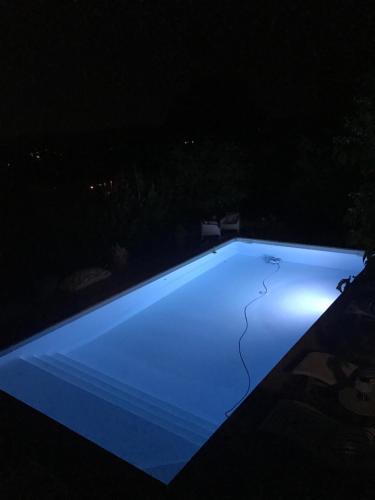 a swimming pool lit up at night at Le jardin secret de Laura in Lorgues