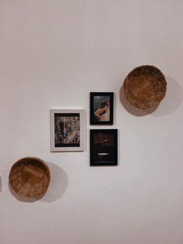 a wall with three pictures on a white wall at Boho Thikana - Homestay in Bir in Jogindarnagar