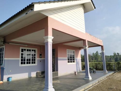 a small pink and white house with a roof at Idaman Homestay 1 in Kampong Gong Kempas