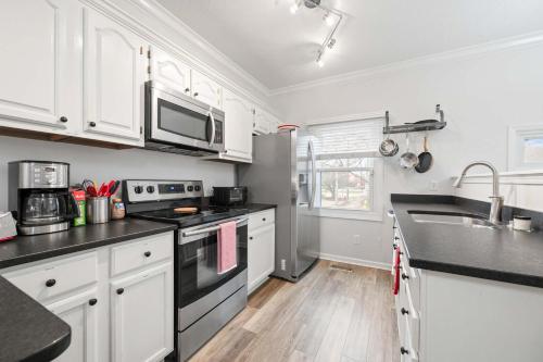 eine Küche mit weißen Schränken und schwarzen Arbeitsplatten in der Unterkunft Mass Ave Gem and steps away from Yoga Studio in Indianapolis