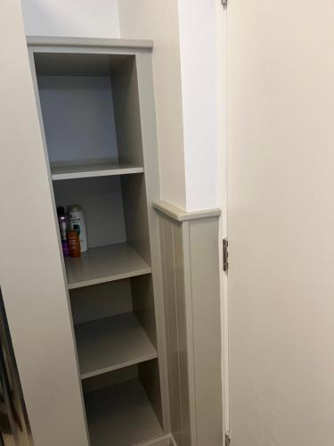 a closet with white shelves in a room at Central town location apartment in Enniscorthy