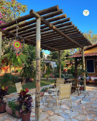 a patio with chairs and a wooden pergola at Pousada Jardim de Minas in Serra do Cipo