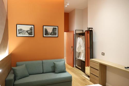 a living room with a blue couch and an orange wall at Xhani's Rooms Durres in Durrës