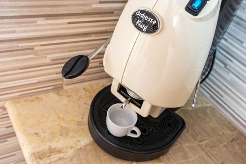 a coffee maker with a cup on a stand at Marea B&B in Gioiosa Marea