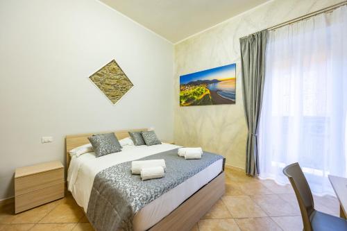 a bedroom with a bed and a table and a window at Marea B&B in Gioiosa Marea