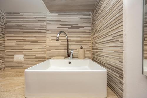 a white sink in a bathroom with wooden walls at Marea B&B in Gioiosa Marea