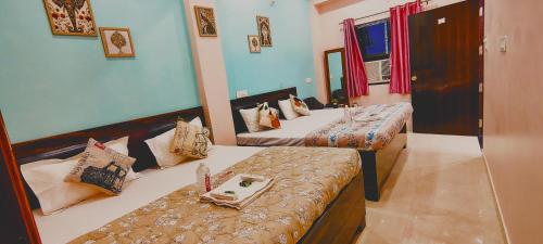 a room with two beds and a table in it at ATULYAM STAYs PREMIUM in Ayodhya