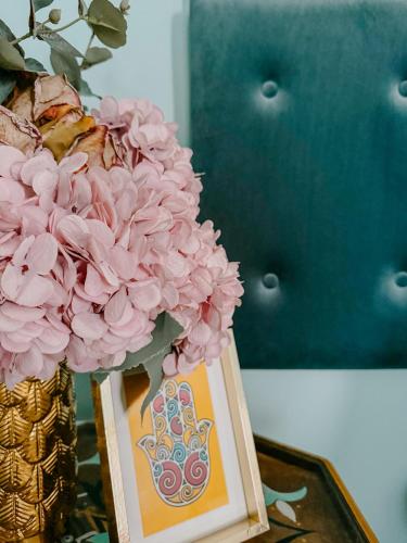 a vase filled with pink flowers on a table at Nour Boutique Hotel in Dahab