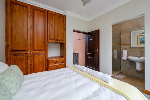 a bedroom with a large white bed and a bathroom at San Lameer Villa 11703 - 5 Bedroom Luxury - 10 pax - San Lameer Rental Agency in Southbroom