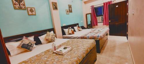 a room with two beds and a bench in it at ATULYAM STAYs PREMIUM in Ayodhya