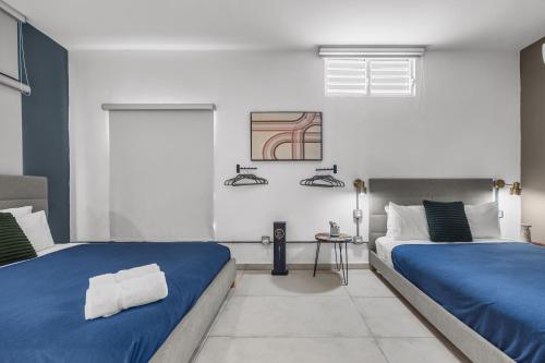 two beds in a bedroom with blue and white at La Buena Vida Inn in San Juan