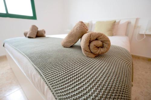 a bed with two stuffed animals on top of it at Casa Kalendra Rofe Tu refugio cerca del mar in Guatiza