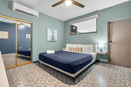 a blue bedroom with a bed and a window at La Buena Vida Inn in San Juan