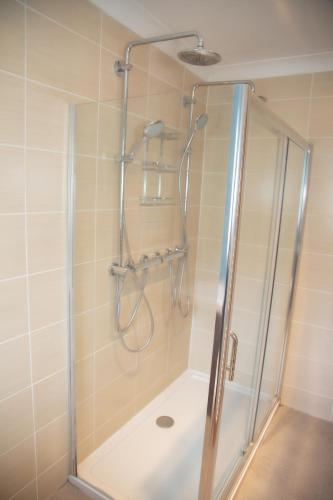 a shower with a glass door in a bathroom at Millbrook Lodge in Lake District National Park