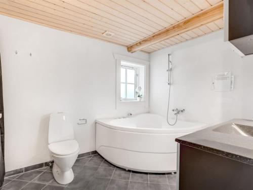 a bathroom with a tub and a toilet and a sink at Holiday Home Edzard - 900m from the sea by Interhome in Marielyst