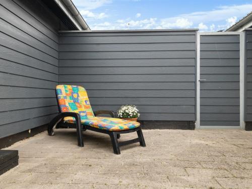 a colorful chair sitting on a patio with a plant at Holiday Home Andine - 250m from the sea by Interhome in Nyborg
