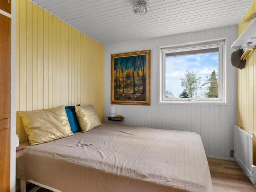 a bedroom with a large bed with a window at Holiday Home Andine - 250m from the sea by Interhome in Nyborg