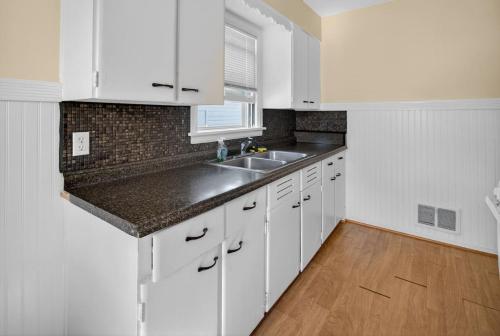 a kitchen with white cabinets and a sink at Quiet room near Rochester hospital in Irondequoit