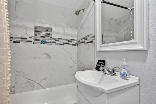 a white bathroom with a sink and a mirror at Unit 19 Tiny Haven Unwind in Pensacola in Pensacola
