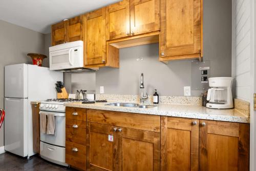 a kitchen with wooden cabinets and a white refrigerator at Downtown Cozy Home Base - Purple Sage 5 in Moab