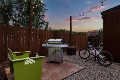 a grill and a bike parked next to a fence at Downtown Cozy Home Base - Purple Sage 5 in Moab