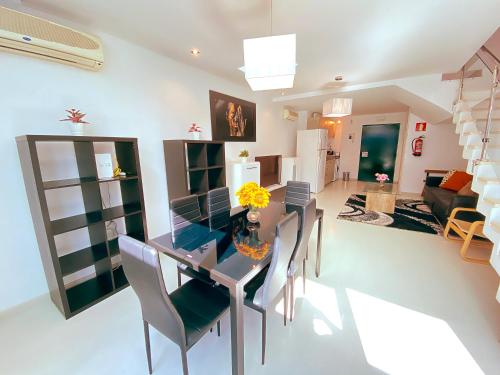 a dining room and living room with a table and chairs at Lumen Triplex by Oshun LOFTS & MIDSTAY in Madrid