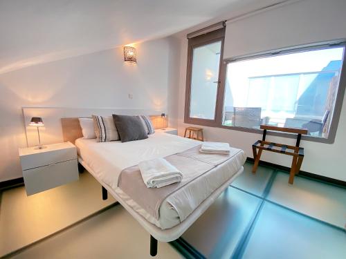 a bedroom with a large bed and a window at Lumen Triplex by Oshun LOFTS & MIDSTAY in Madrid