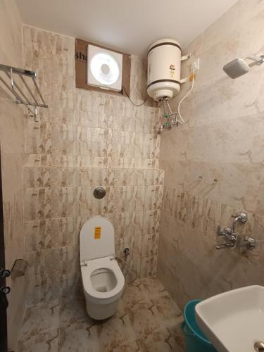 a small bathroom with a toilet and a sink at Kashi V Homestay in Varanasi