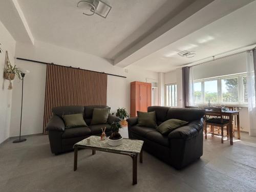 a living room with two couches and a table at Appartamento Il Giglio in La Morra