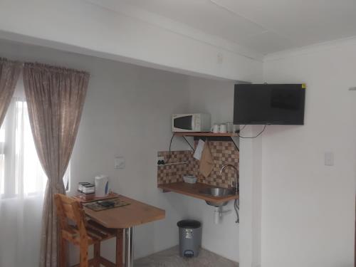 Una televisión o centro de entretenimiento en Shalom Self Catering