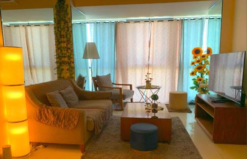 a living room with a couch and a tv at Mactan Newtown - New Modern Condo with Ocean View in Mactan