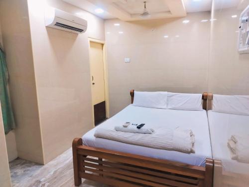 a bedroom with a bed with towels on it at Hotel Mtc Guest House in Chennai