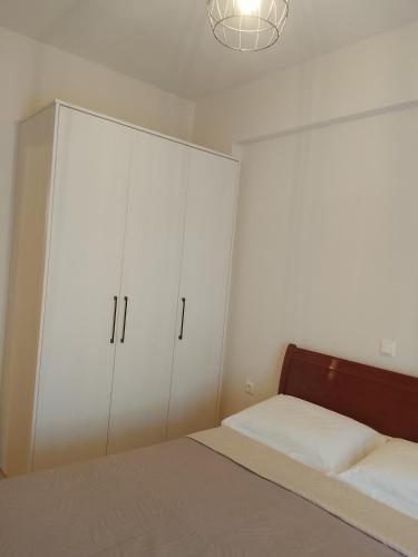 a bedroom with white cabinets and a bed at ΔΙΑΜΈΡΙΣΜΑ ΜΕΝΤΗΣ in Igoumenitsa