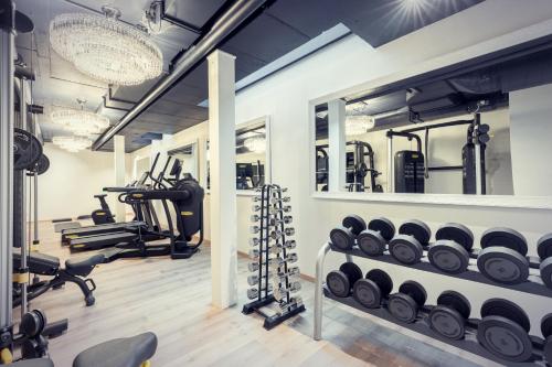 a gym with treadmills and machines in a room at Le Mirabeau Resort & Spa in Zermatt
