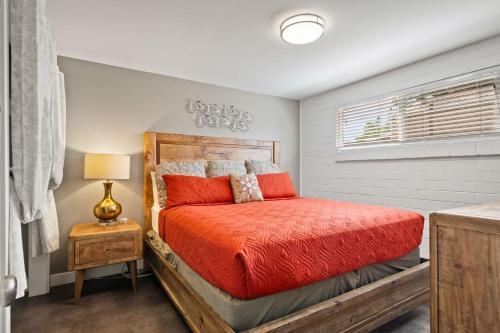 a bedroom with a bed with a red comforter at Downtown Cozy Home Base - Purple Sage 6 in Moab