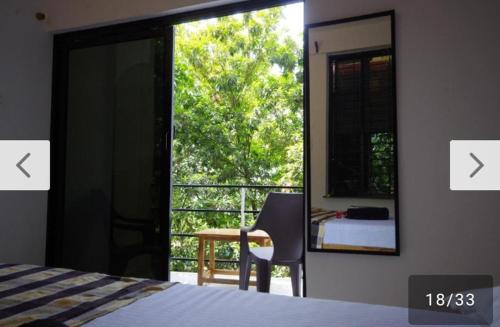 a bedroom with a bed and a mirror and a balcony at Angelo's place in Arambol