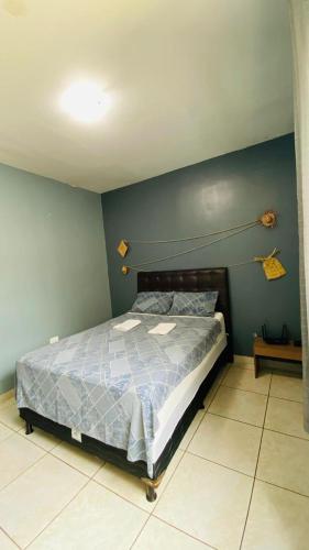 a bedroom with a bed and a blue wall at Aconchego na Capital do Forró in Caruaru