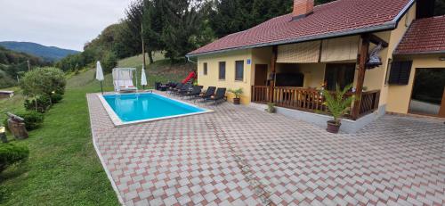 a house with a swimming pool in the yard at VILA LASOVIC + POOL + JACUZZI + SAUNA in Tuhelj
