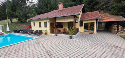 a house with a swimming pool in front of it at VILA LASOVIC + POOL + JACUZZI + SAUNA in Tuhelj