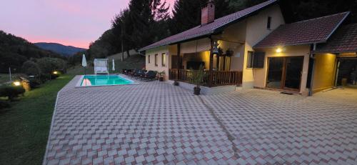 a house with a swimming pool next to a house at VILA LASOVIC + POOL + JACUZZI + SAUNA in Tuhelj