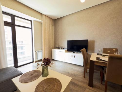 a living room with a dining table and a television at Stylish Apartment in Prestigious Towers in Baku in Baku