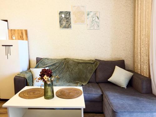 a living room with a couch and a table at Stylish Apartment in Prestigious Towers in Baku in Baku