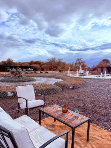 a patio with a table and chairs and a fountain at MAKTVB - EcoLodge San Pedro de Atacama in San Pedro de Atacama