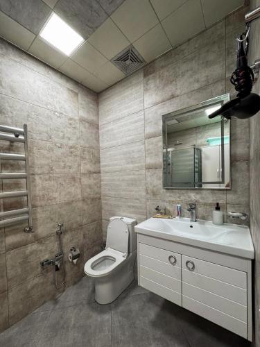 a bathroom with a toilet and a sink and a mirror at Stylish Apartment in Prestigious Towers in Baku in Baku